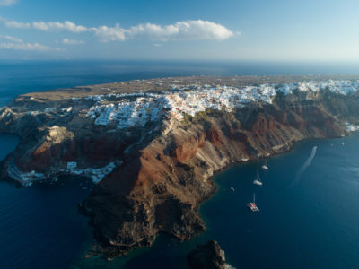 Aerial view flying over city of Oia on Santorini Greece, early morning